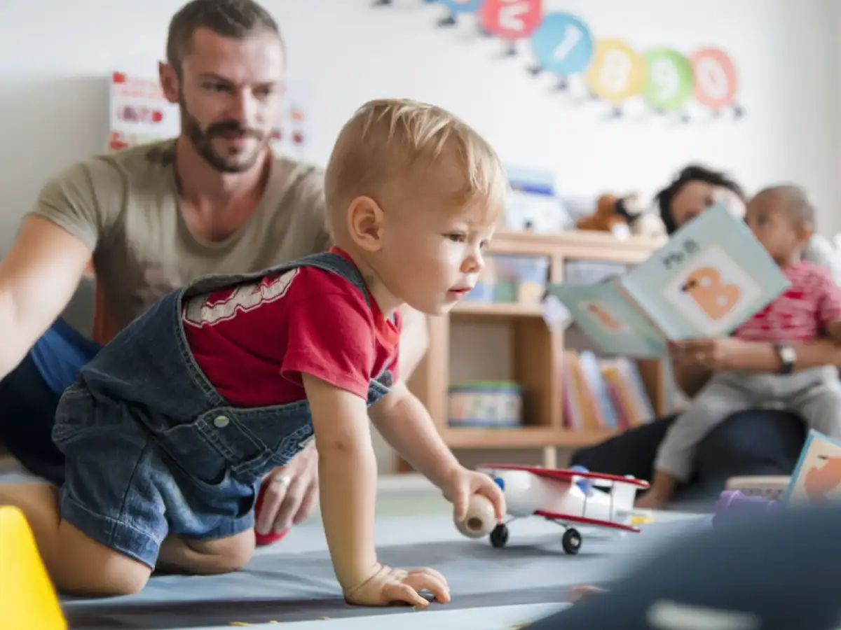 An infant boy playing with toys in a daycare